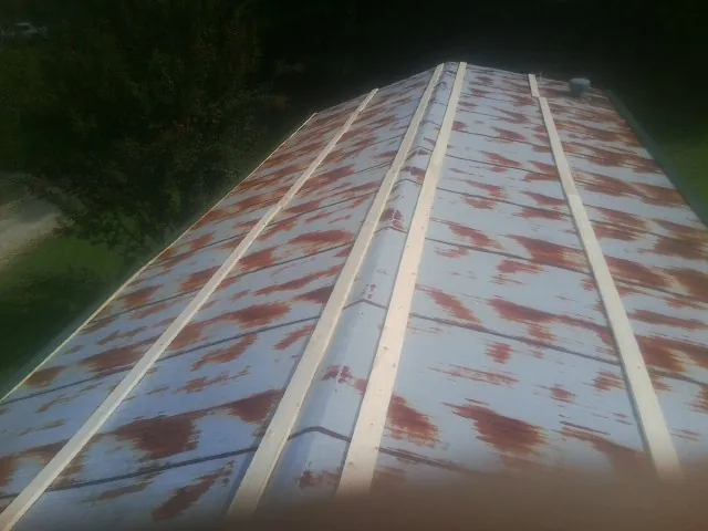 Rusted metal roof panels with new wood purlins before replacement — Storm Damage Roof Repair in Loganville by Roofing Brothers