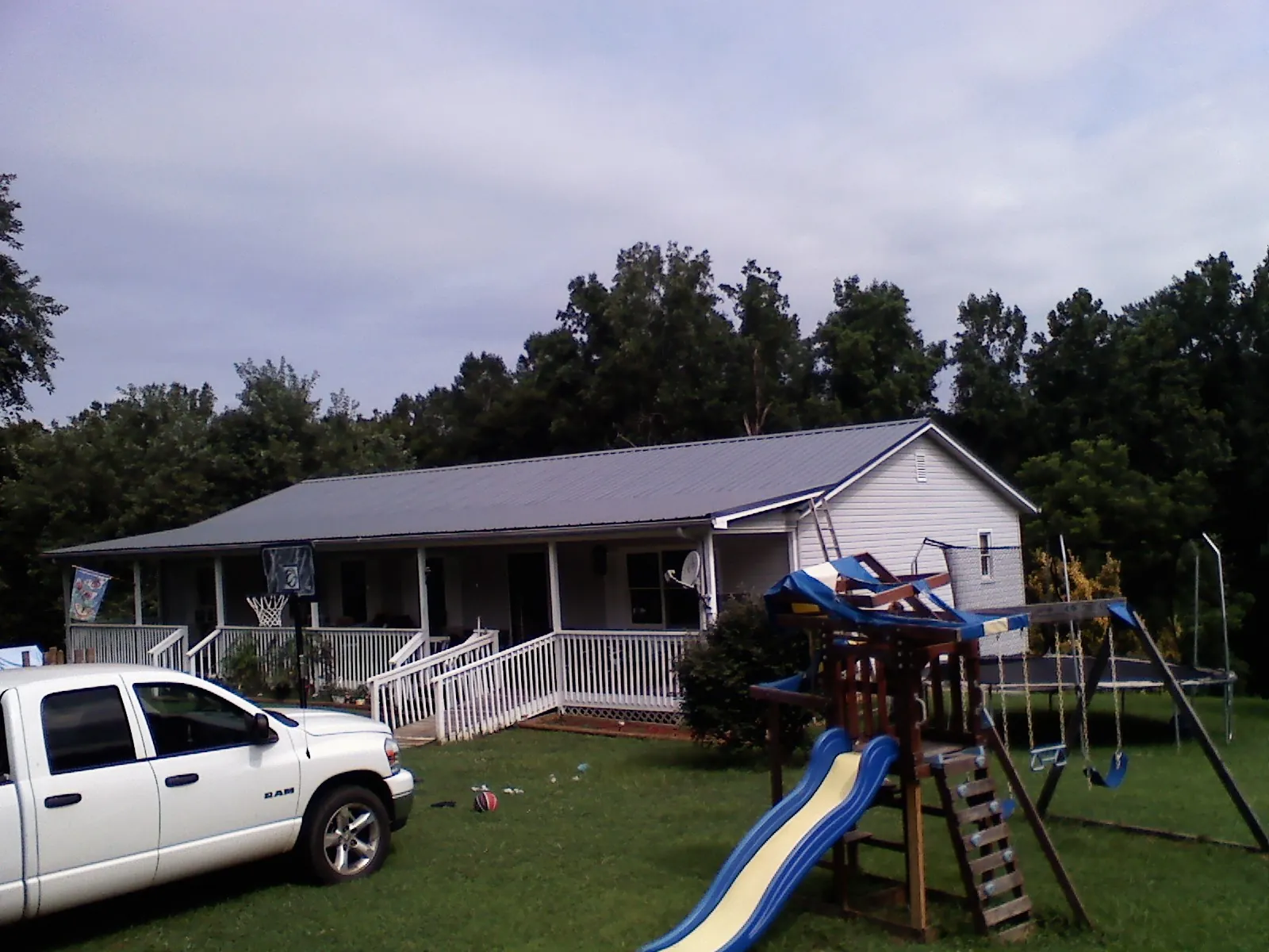 Dark metal roof on a country home with a full length front porch in Loganville