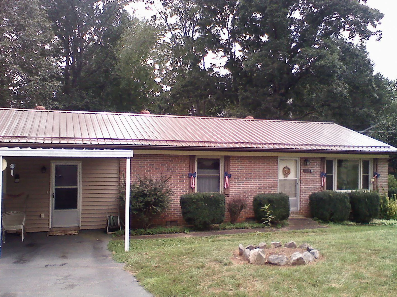 Bronze metal roof and carport on a brick ranch home — Roof Repair work by our crew in Loganville